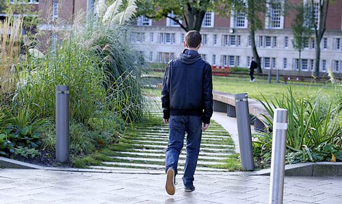 male student walking through campus grounds