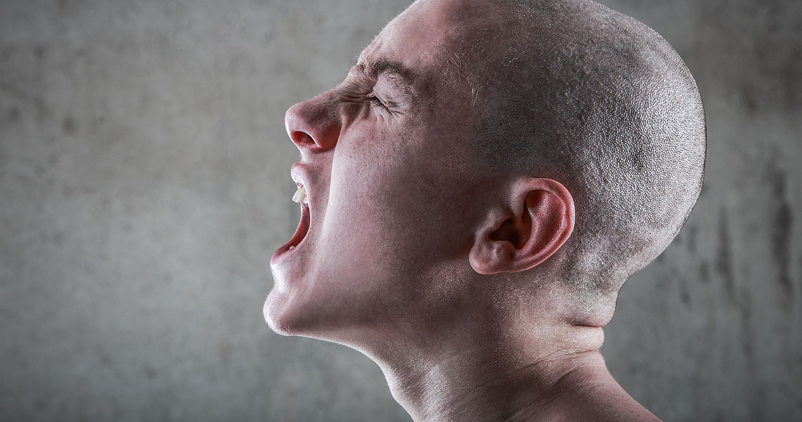 Young man with a skinhead in profile screaming