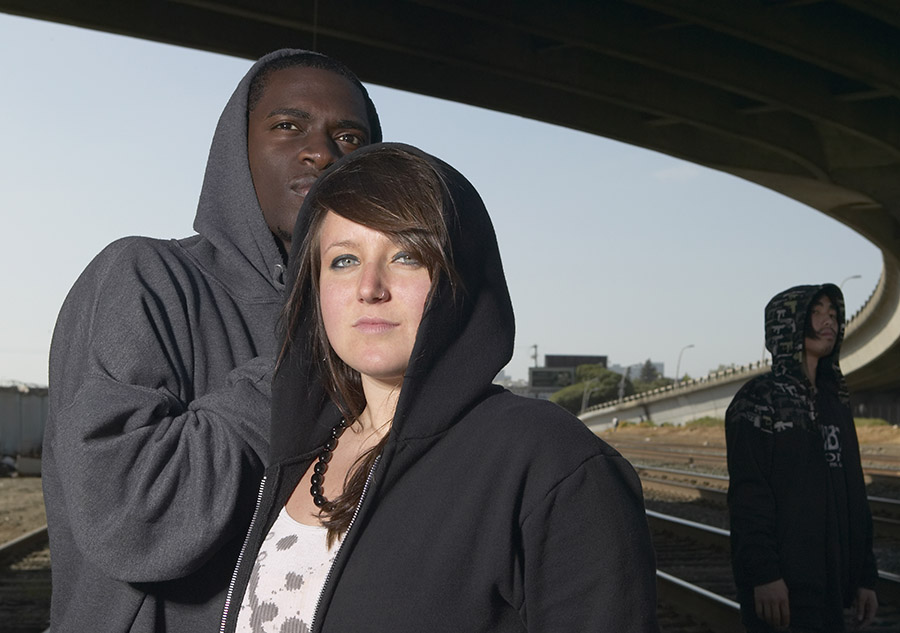 Three young people in hoodies in an urban setting