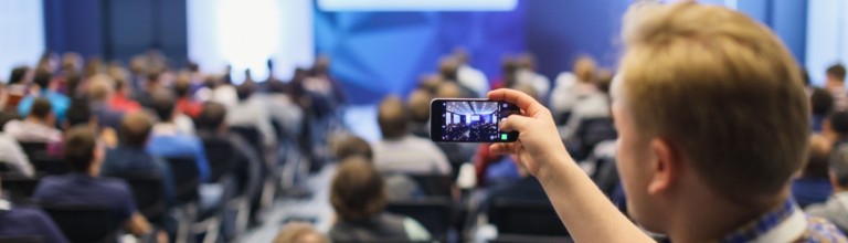 A student taking a photo of a full lecture theatre 