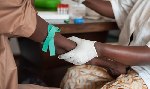 A medical professional giving an injection into someone's arm.