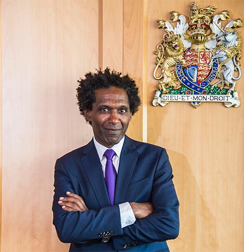 Lemn Sissay in front of the crest in the moot room