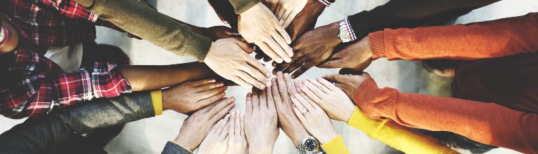 A diverse group of hands together.