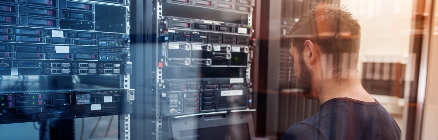 IT Engineer with thin aluminium laptop in network server room