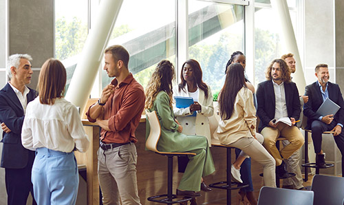 Diverse business professionals communicating at a conference, seminar or other educational event. Young and mature multiethnic people meeting in the office and having discussions.