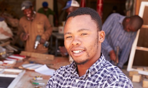 South African man with workers in the background.