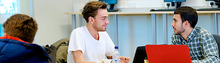 male students chatting at desk